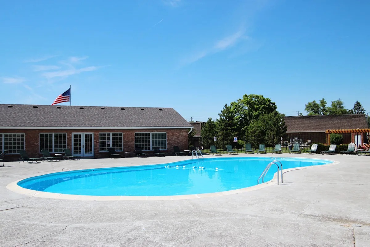 A swimming pool in front of a building with an American flag