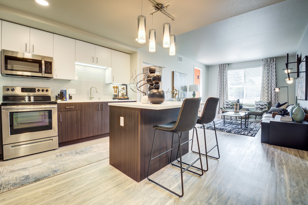 Vinyl-floored kitchen with two-tone cabinets, quartz counters, and stainless steel appliances.