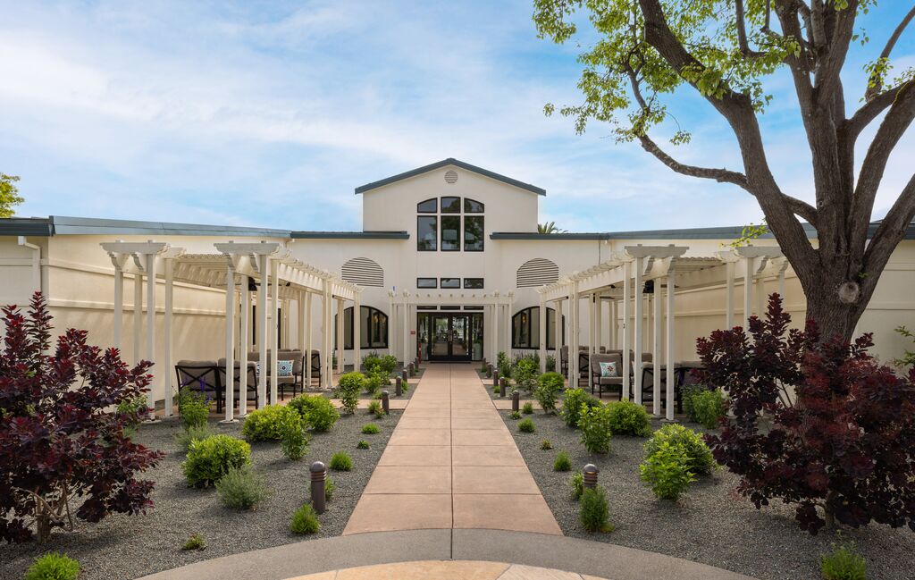 The path in sets the tone. Manicured gardens, open-air pergolas, and a destination that earns the journey.