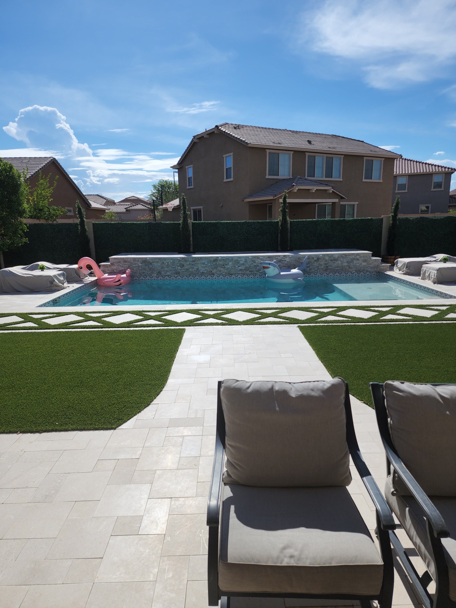 A completed backyard transformation featuring a custom swimming pool, clean geometric hardscape, art 