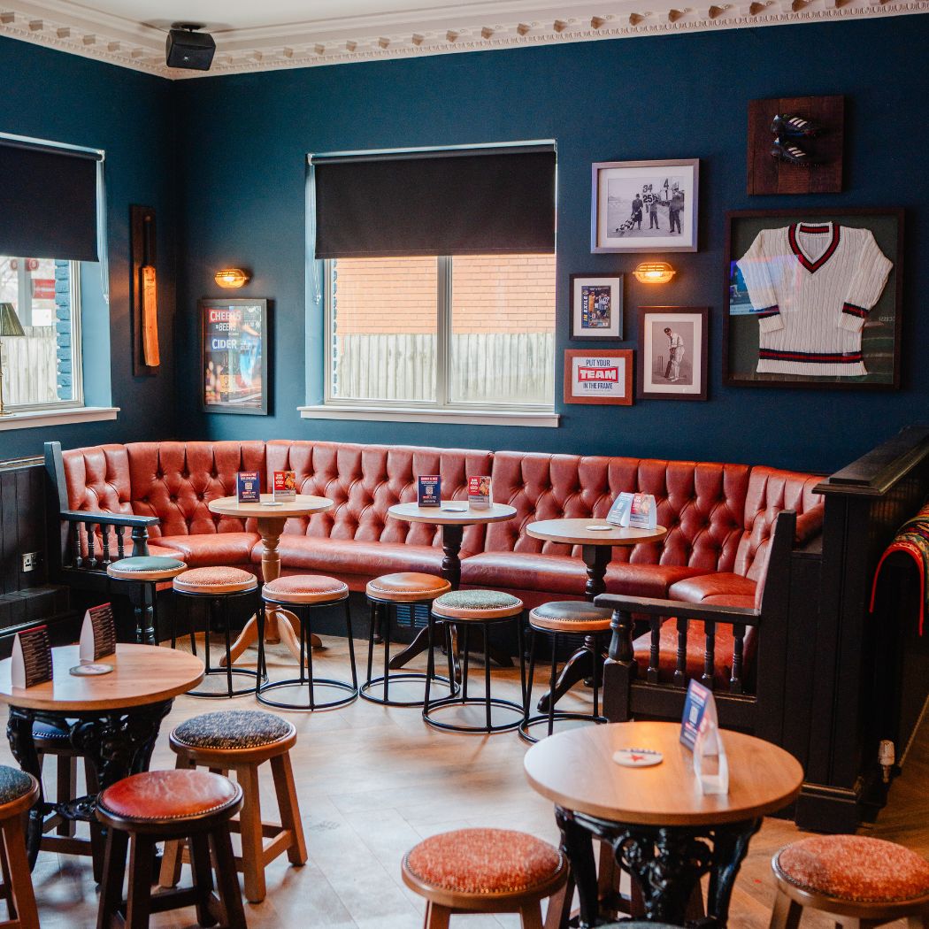 Comfortable booth seating area with framed sports memorabilia, offering a relaxed space for drinks and casual dining.