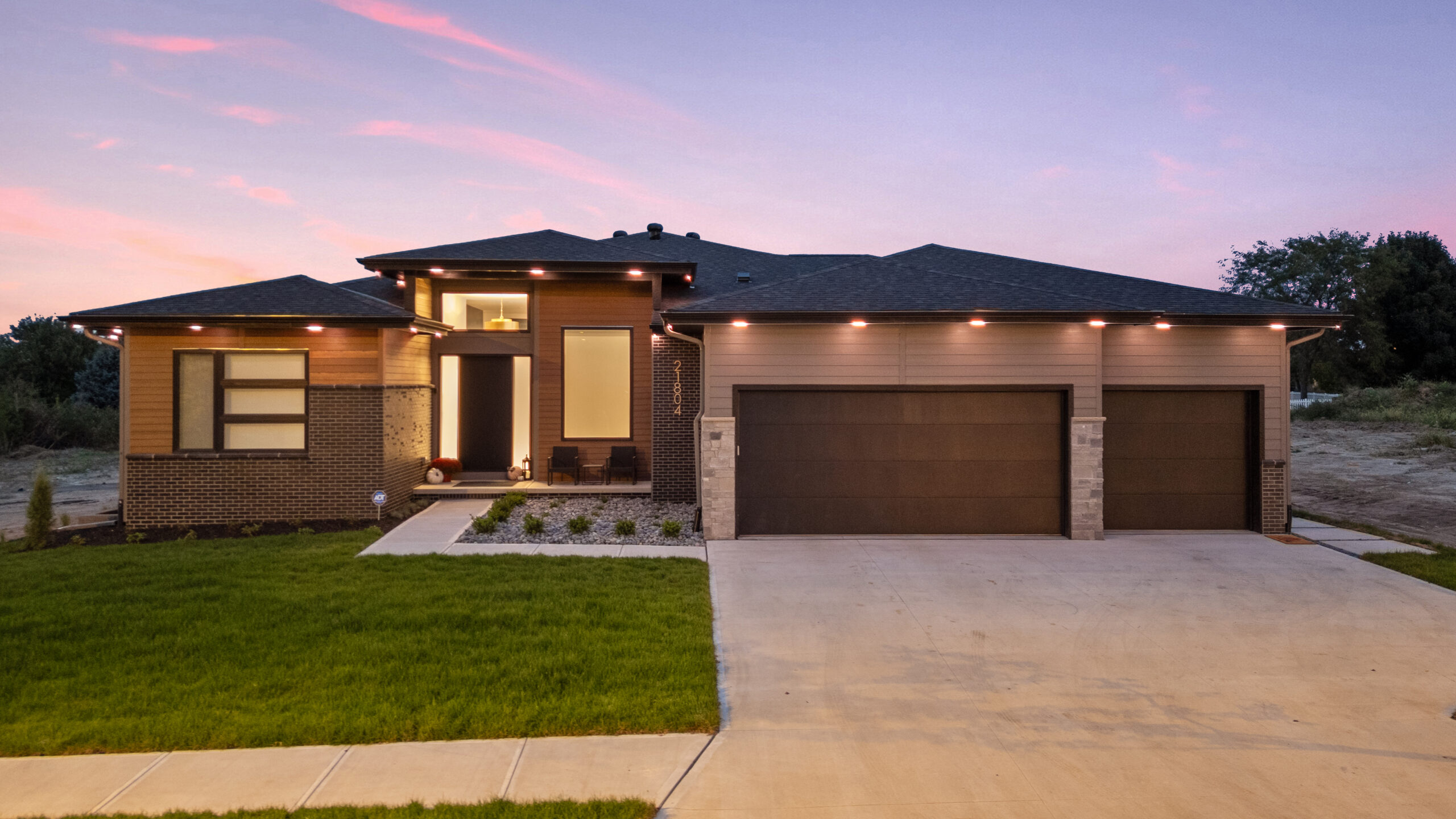 Professional outdoor lighting enhancing the front elevation, garage, and architectural features of a modern home.