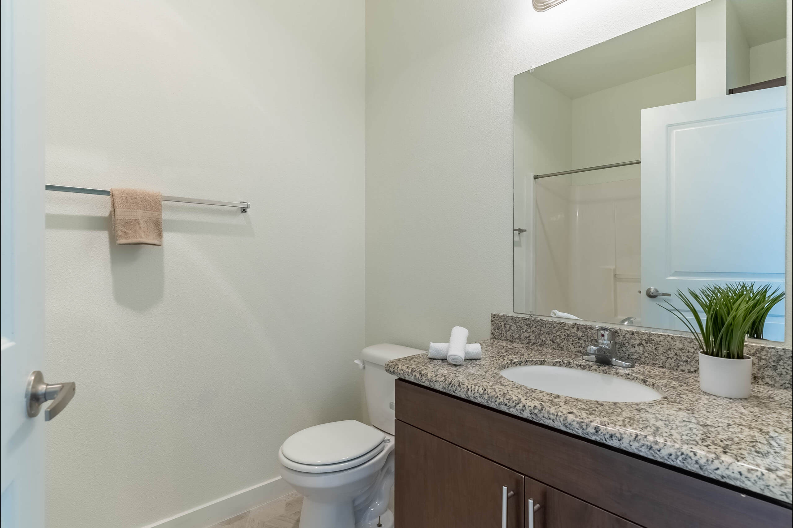 A bathroom with a toilet, sink, and mirror.