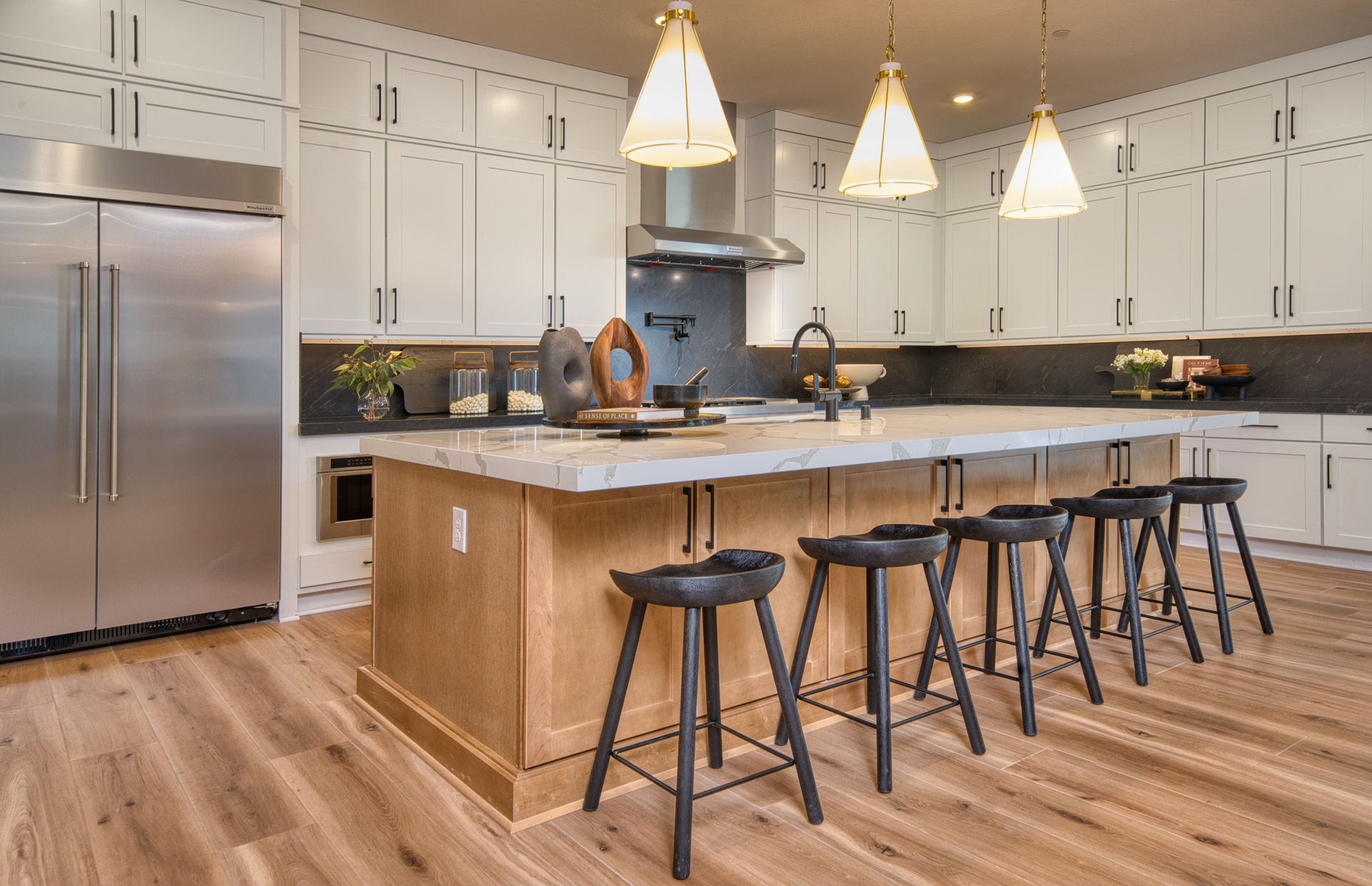 Kitchen in Luminary floor plan includes island with seating and sink at Daylight new construction homes in Las Vegas, NV