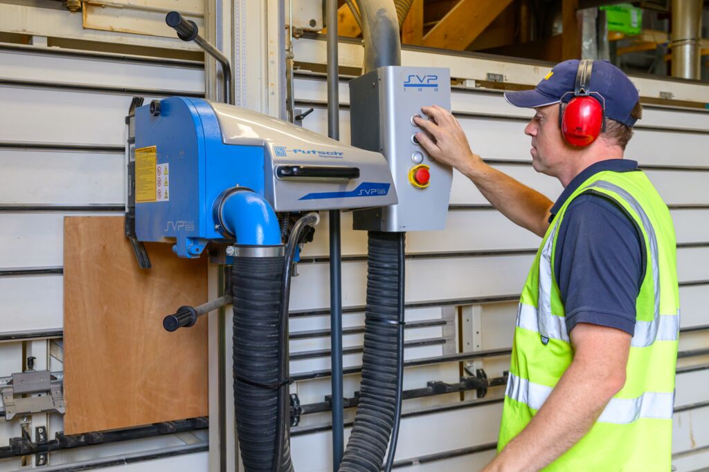 Image of man in hi-vis cutting sheet material