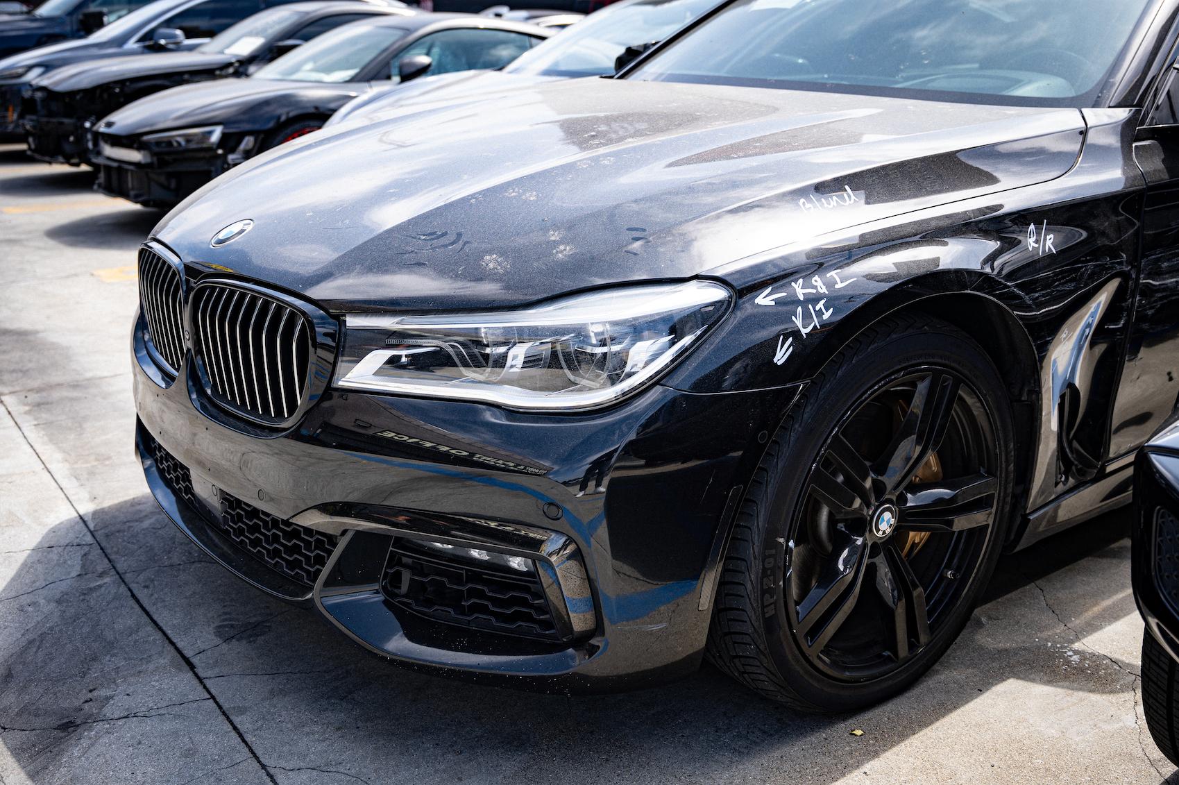 Detailed photo of BMW sedan waiting at auto body shop parking lot for collision repair