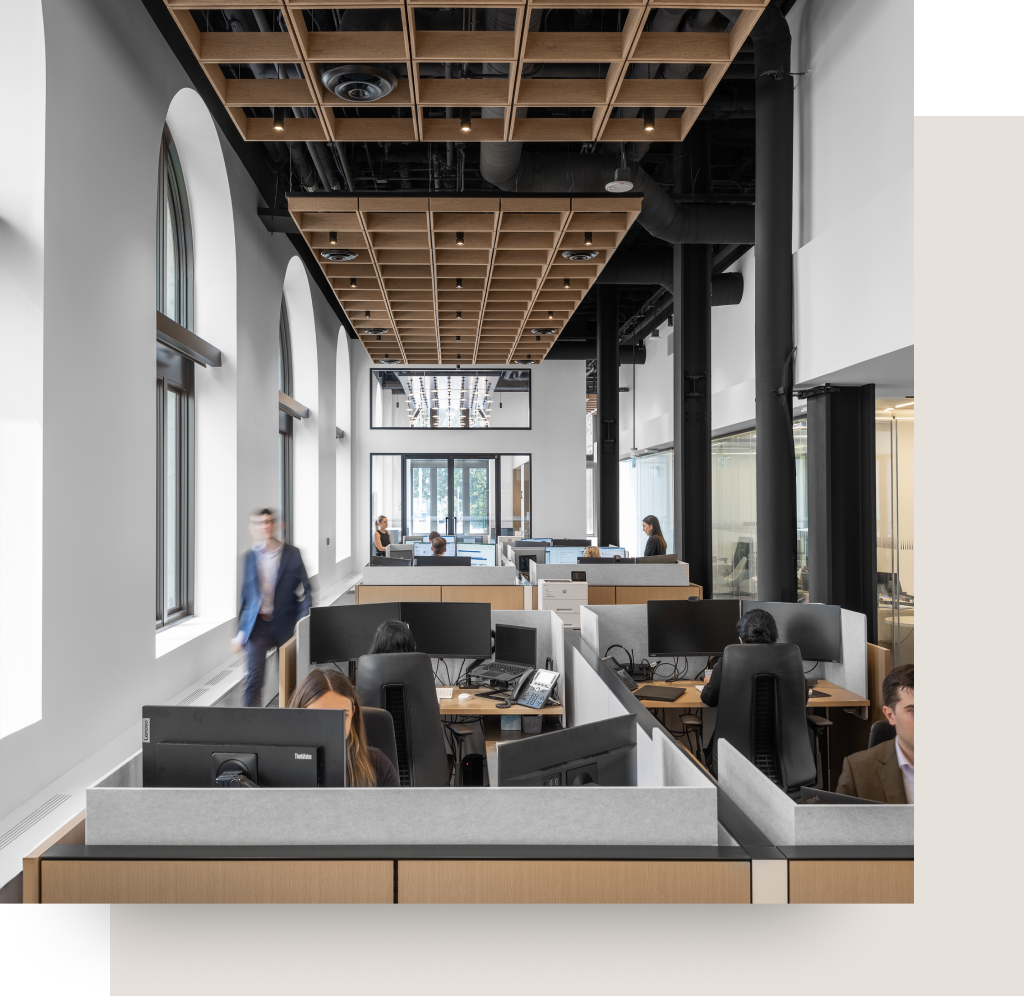 Professionals working at their desks in the modern, bright Ascendant Wealth Partners office.