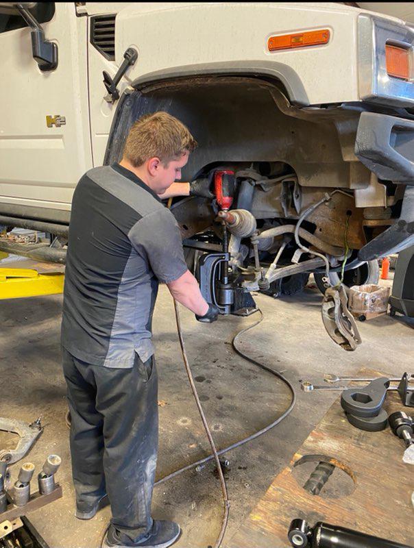 C H Auto Repair mechanics working on a vehicle.