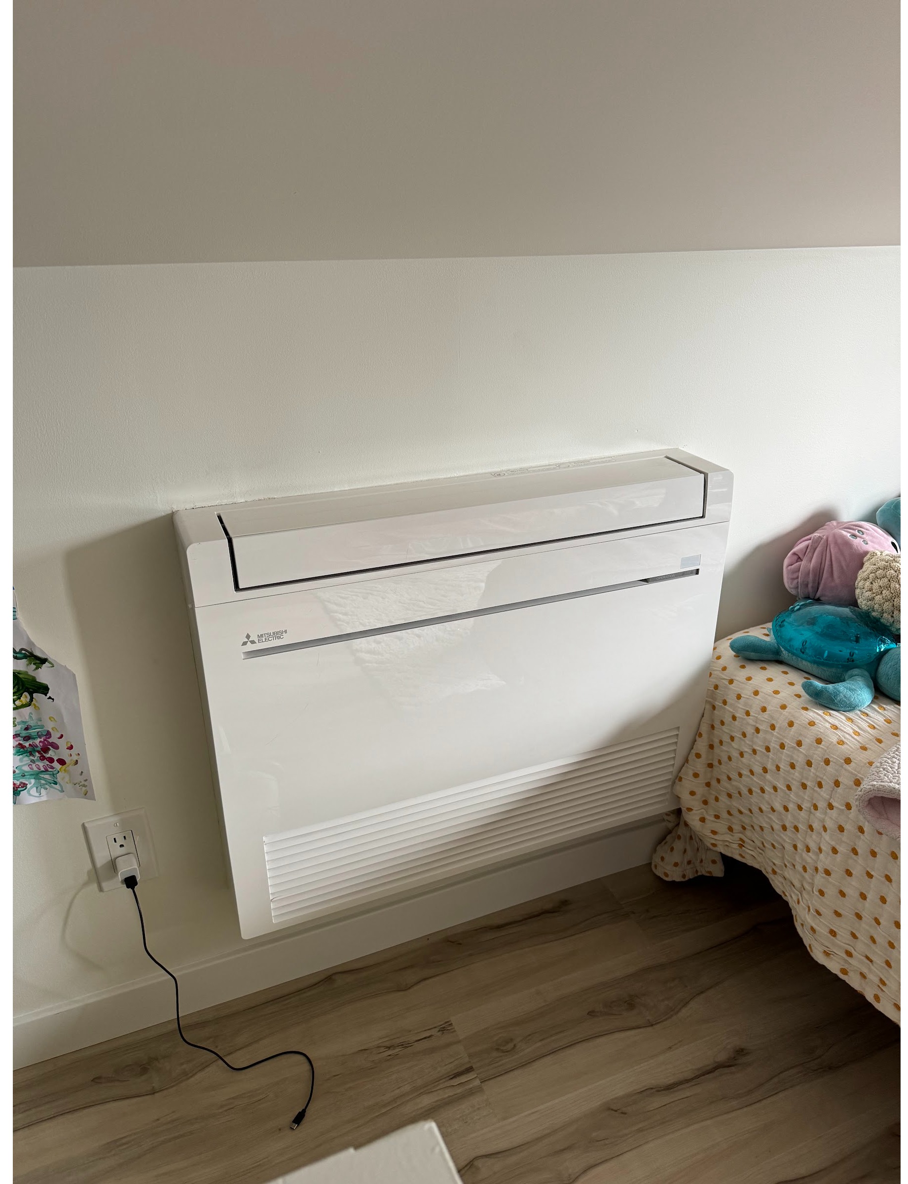 Mitsubishi floor-mounted ductless mini split installed in a bedroom. Room-by-room heating and cooling from Ready Energy Solutions.