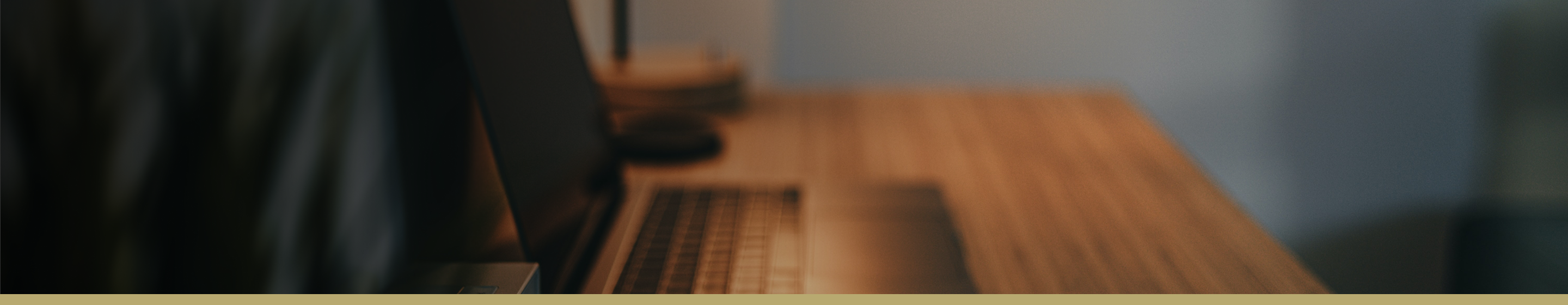 Blurred photo of an open laptop on a desk.