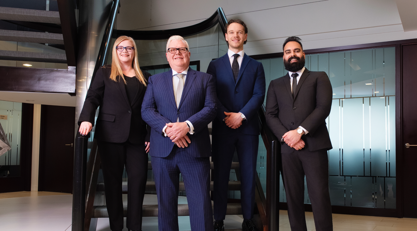 The Thompson Wealth Partners team standing side by side in their office.