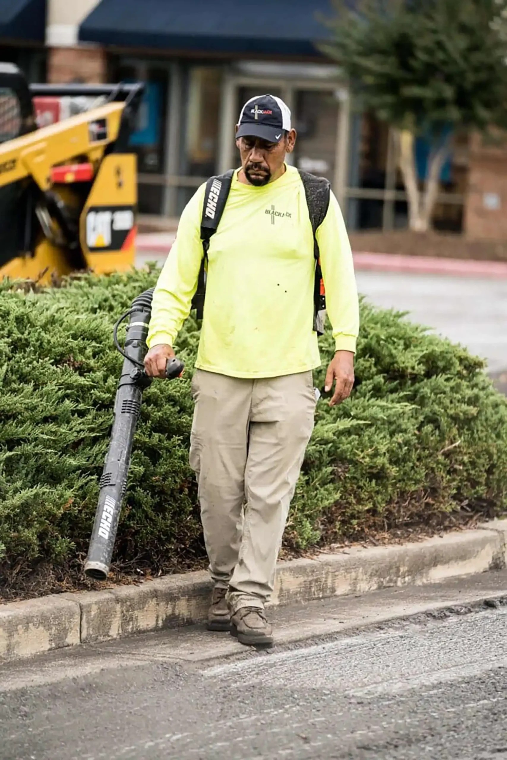 Blackjack technician cleaning up debris before a paving project