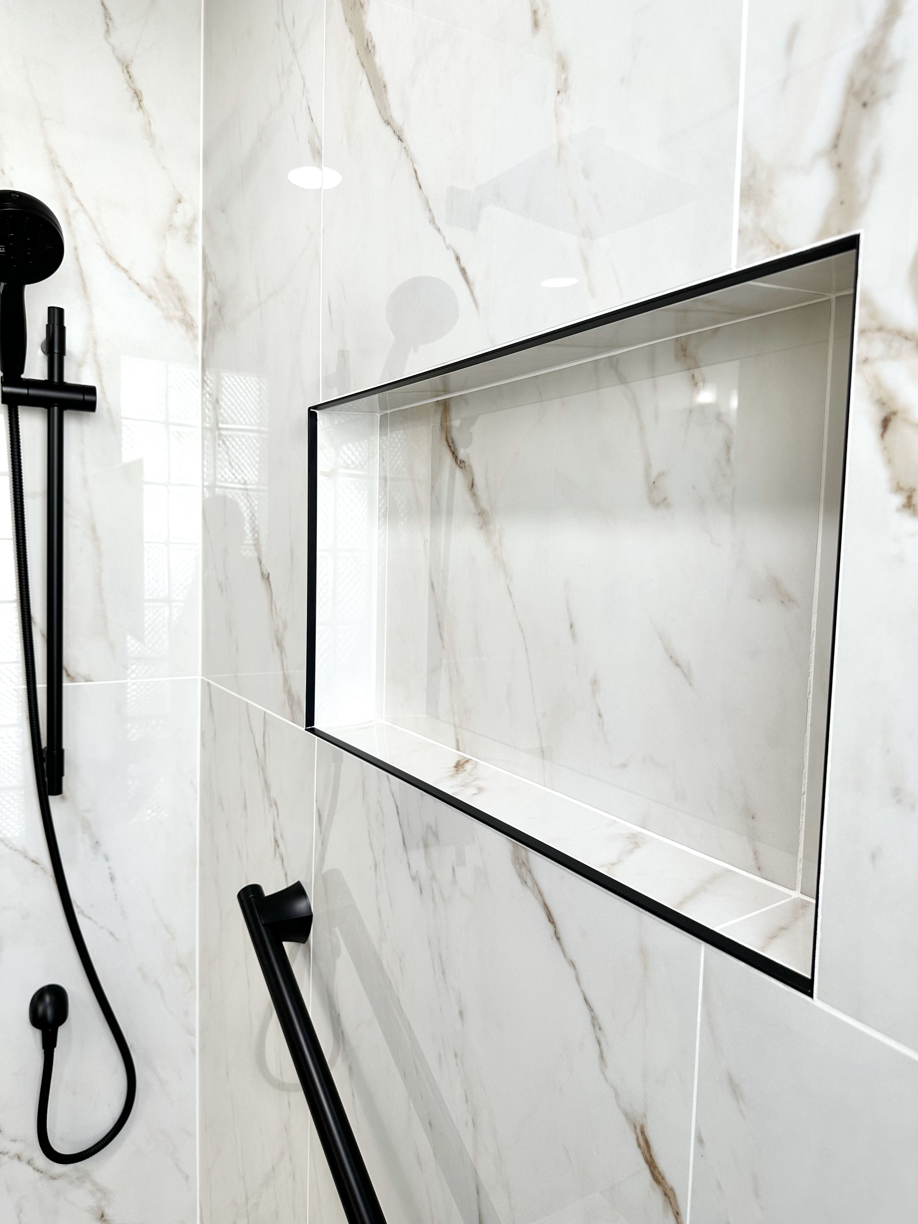 This shower was transformed with a sleek and modern renovation, featuring elegant marble-look tiles and a stylish built-in niche with black trim. The matte black fixtures add a sophisticated contrast, blending functionality with high-end design. As a trusted bathroom remodeling contractor, Ledezma Remodeling ensures every detail enhances aesthetics and convenience.