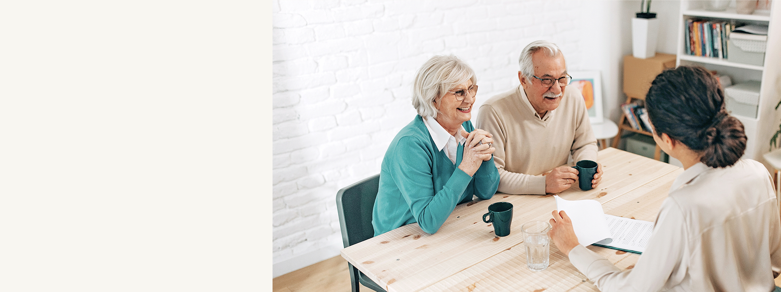 Senior clients speaking with an advisor across a table.