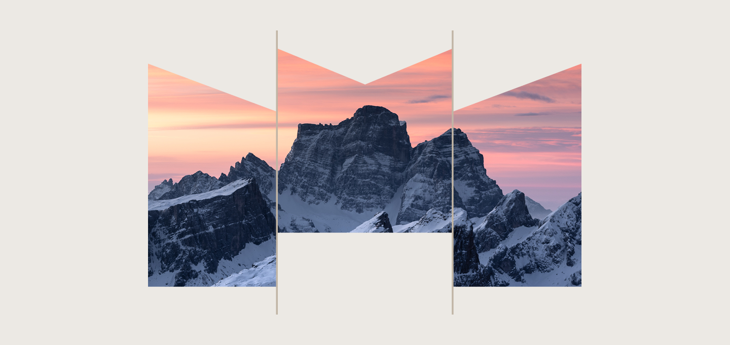 A snow-capped mountain range beneath a beautiful pink sky.