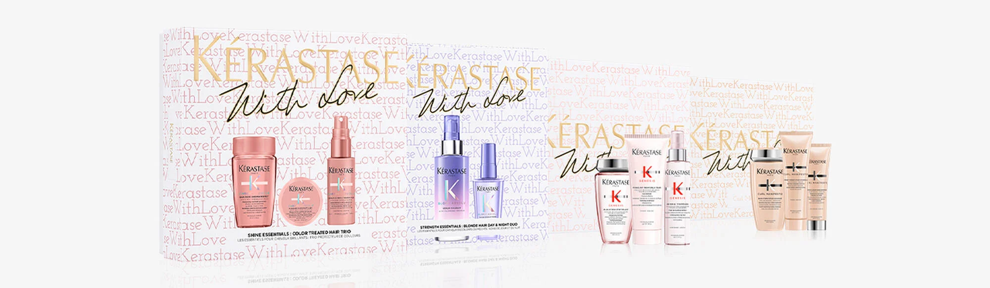 A collection of Kerastase hair care products is displayed against a backdrop featuring the brand's logo and the phrase 'With Love' repeated in various fonts and colors. The products are arranged in groups, with pink-toned bottles and tubes on the left and purple-toned bottles in the middle, followed by more pink and beige-toned products on the right. Some products have labels indicating their intended use for color-treated hair, blonde hair, and curl enhancement.