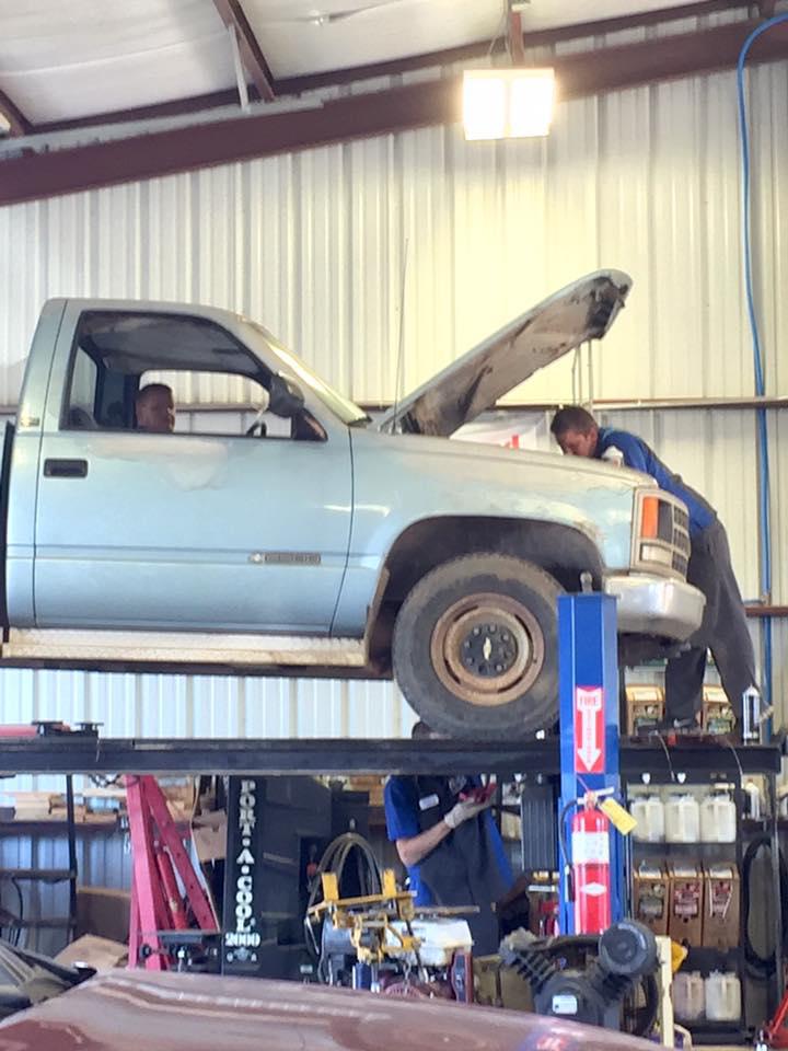 C H Auto Repair Mechanic working on a vehicle.