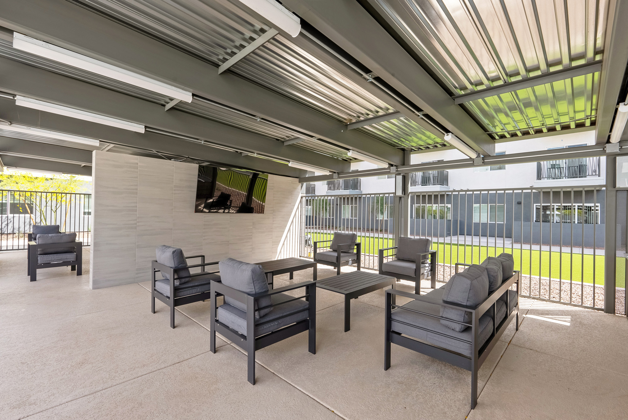 Outdoor lounge area with adjustable shade pergola