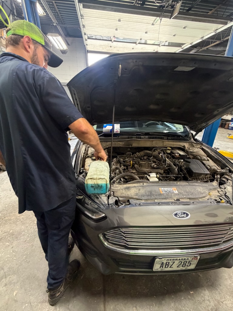 Walker Tire Point S technician performing preventive maintenance on a vehicle at our Downtown Lincol 