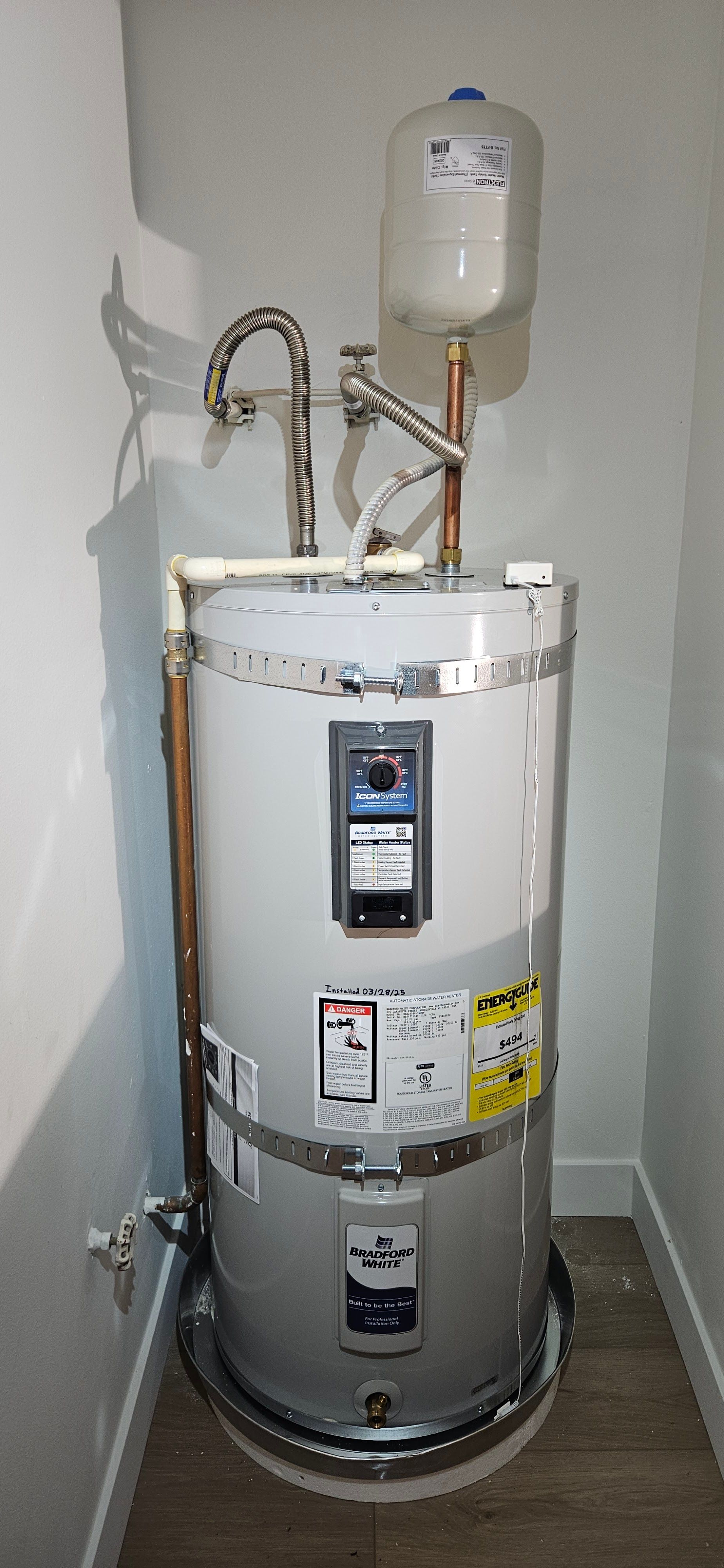 Residential water heater installation with expansion tank, copper supply lines, flexible connectors, 