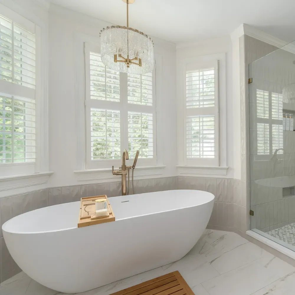 Custom bathroom renovation in Central North Carolina featuring a freestanding soaking tub, large windows, and bright natural light. This luxury bathroom remodel highlights elegant design and expert residential construction near the Badin Lake area.