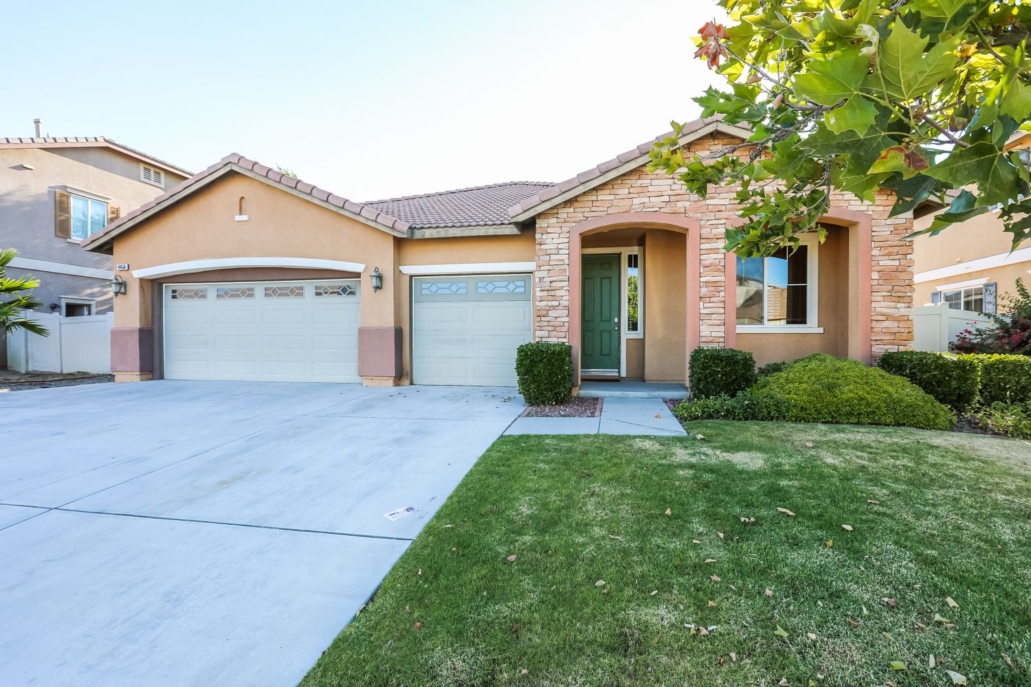 Front yard of home with three-car garage at Invitation Homes Pasadena.