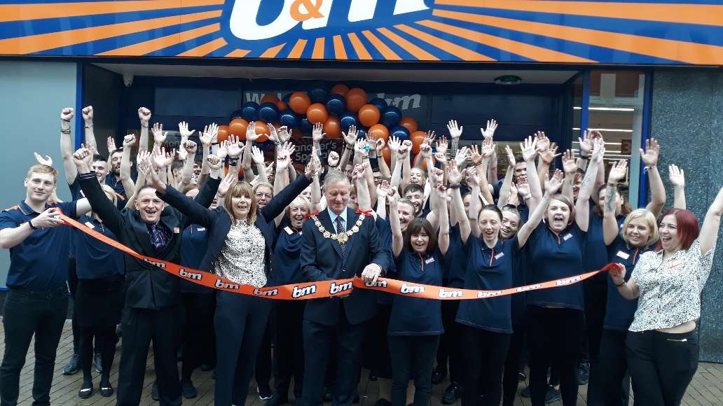 Store staff at B&M's newest store in Dover celebrate as local mayor, Councillor Gordon Cowan cuts the ribbon to officially open the store.