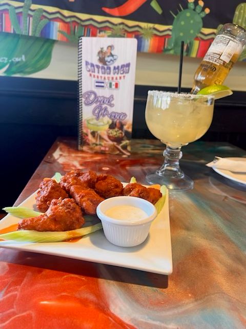 Crispy buffalo wings tossed in spicy sauce and served with a creamy dipping sauce at Catramex Restaurant.