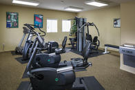 Fitness center with cardio machines, weight machines, and water fountain.