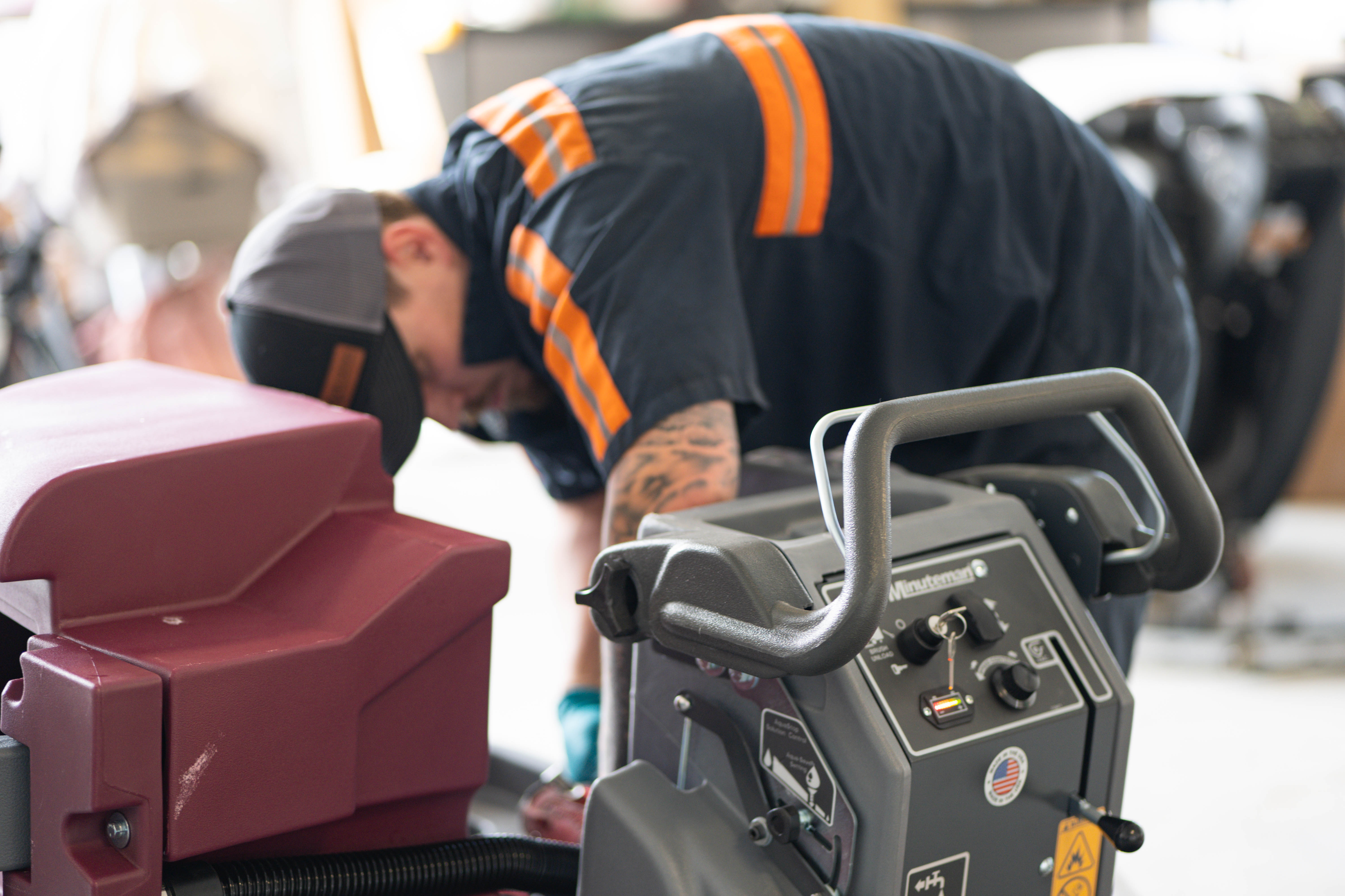 An expert WaySolutions mechanic utilizes a professional, fully stocked tool bag to repair the lower brush deck of a teal Tennant T3 FAST walk-behind floor scrubber. We deliver top-tier mechanical diagnostics, parts replacement, and repair services for commercial cleaning equipment right at your facility in Layton, Utah