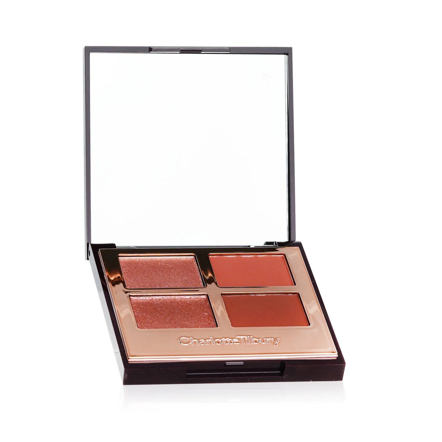 A Charlotte Tilbury palette with four shades of blush and eyeshadow is shown on a white background. The palette is open, revealing the four pans and a mirror. The case is a dark brown with rose gold accents, and the brand name "Charlotte Tilbury" is embossed on the front.