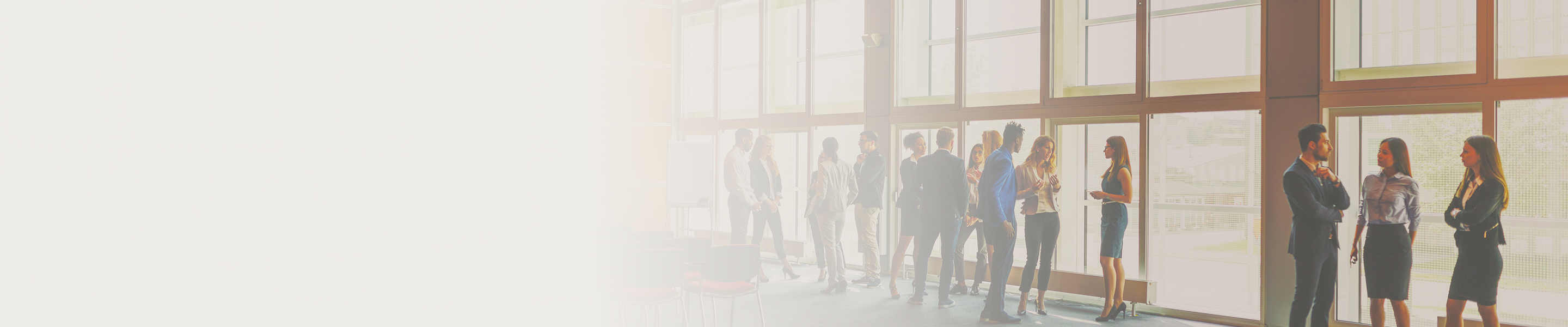 A small crowd of business professionals conversing in a conference room.