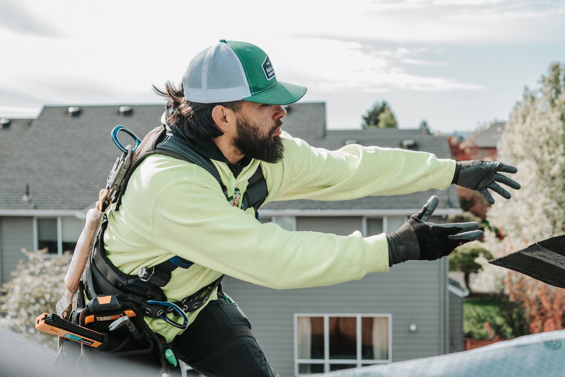 Roofer moving material during a residential roofing project. 
