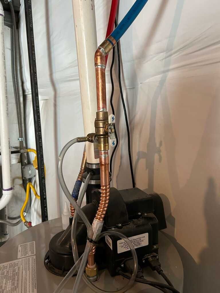 Residential water heater connection features copper piping, flexible tubing, valves, wiring, and nea 