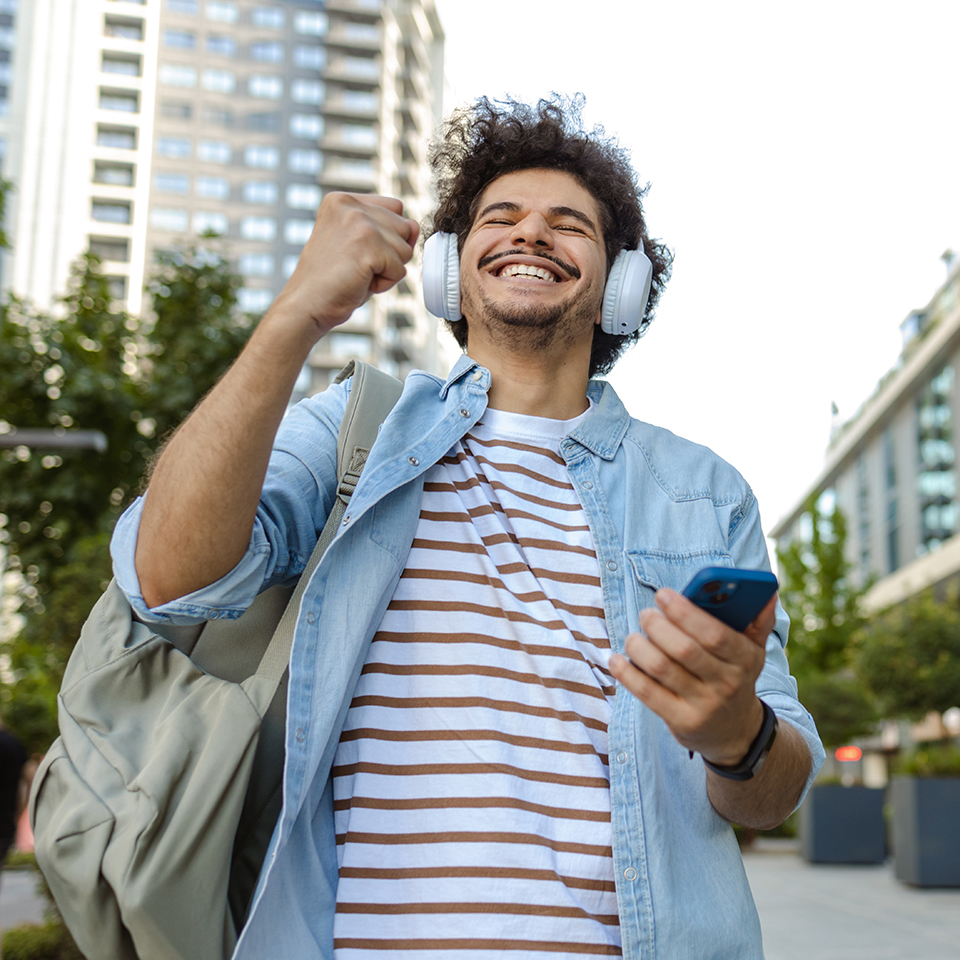 Man holding a phone an pumping his fist in celebration