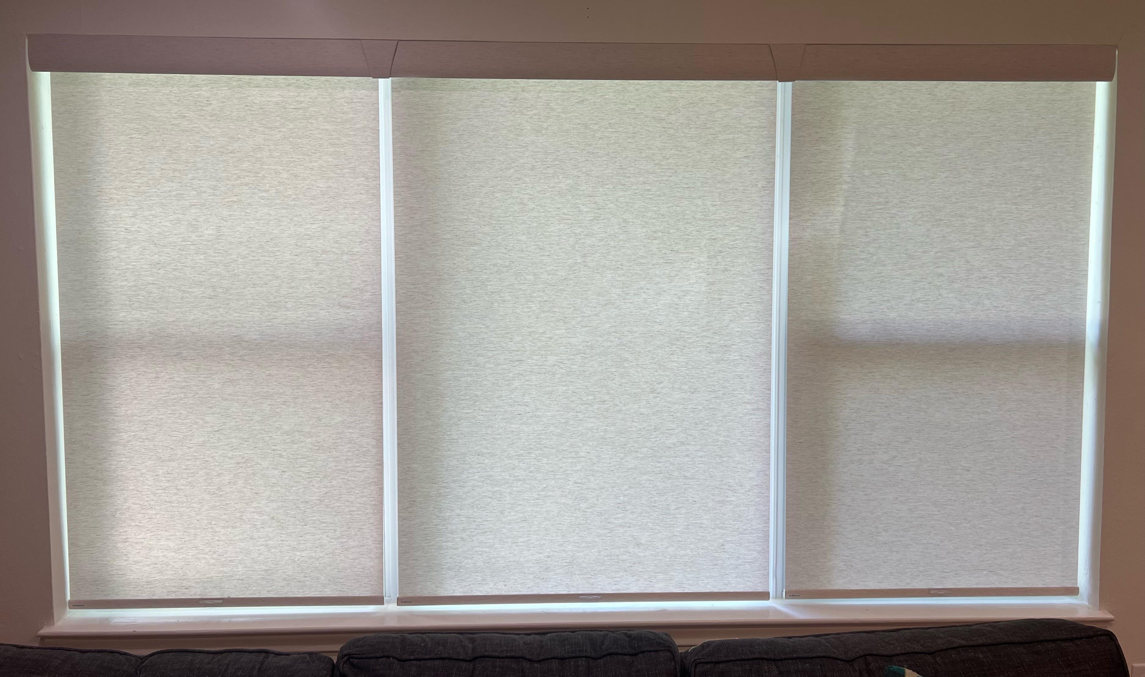 Cordless roller shades with light filtering fabric on three side by side windows with one valance is the perfect solution for diffusing natural light with added privacy. Our team at Budget Blinds of Rockwall, Terrell, and Greenville can help you select the best options for your unique window needs.