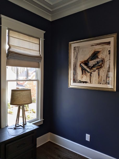 What do you think of the deep blue the walls of this bedroom are painted? This color makes the white trim and lighter design pieces stand out. Like our custom Roman Shade installed in the window!