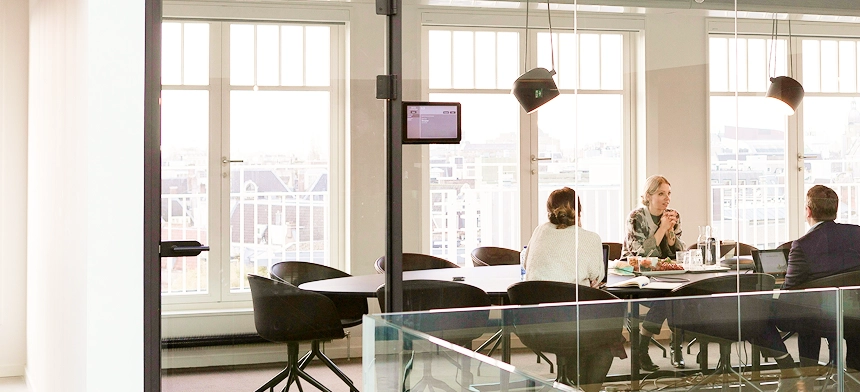 Four people meeting in a board room.