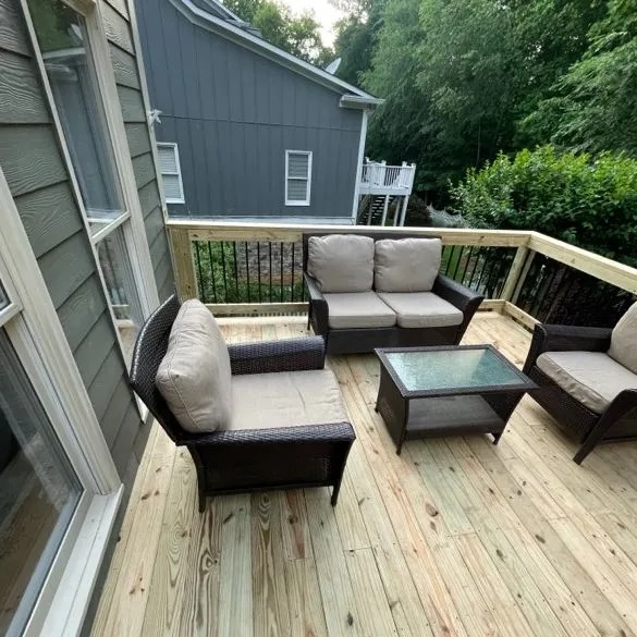 Cozy patio deck with outdoor furniture including chairs, sofa, and table.