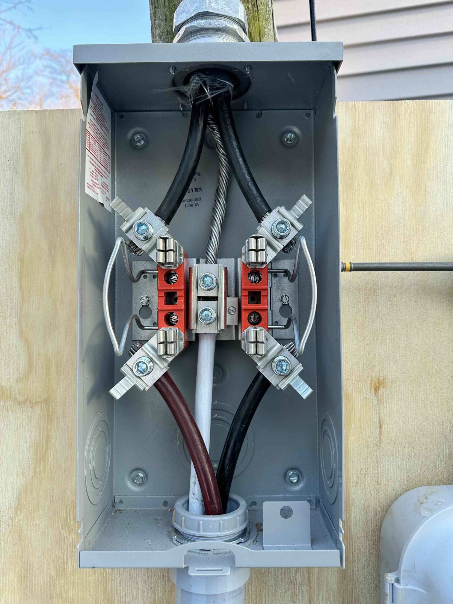 A close-up of a newly wired meter base installed by Thomas Edison Electric at a Lebanon, PA property. The service entrance conductors are securely terminated to the line-side lugs with proper torque, and an inspection sticker is visible confirming code compliance.