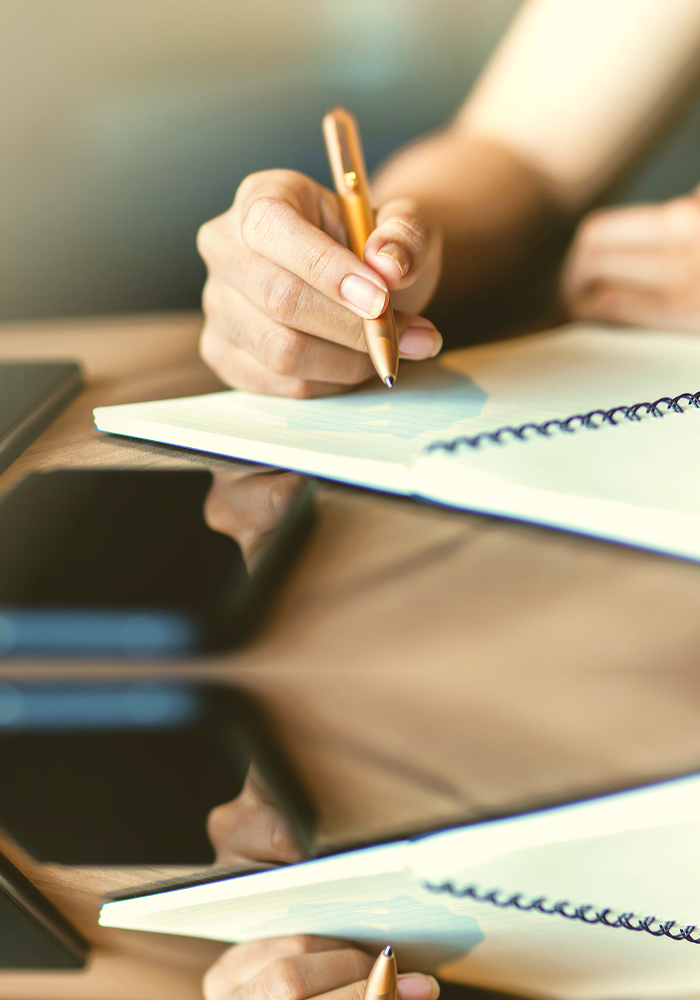 Close-up of someone writing in their journal.