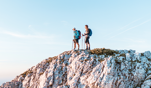 Two people hiking to the top of a mountain.