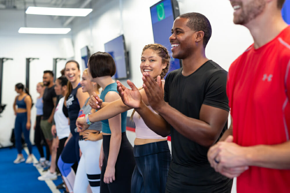 F45 members and a trainer encouraging one another during a team workout. 