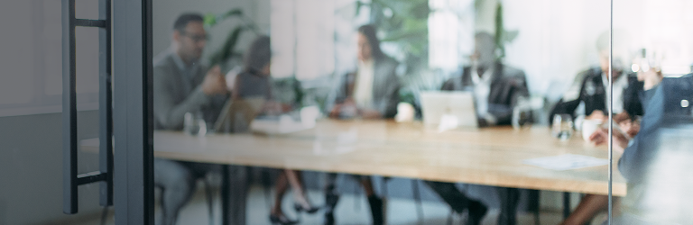 Professionals working around a boardroom table.