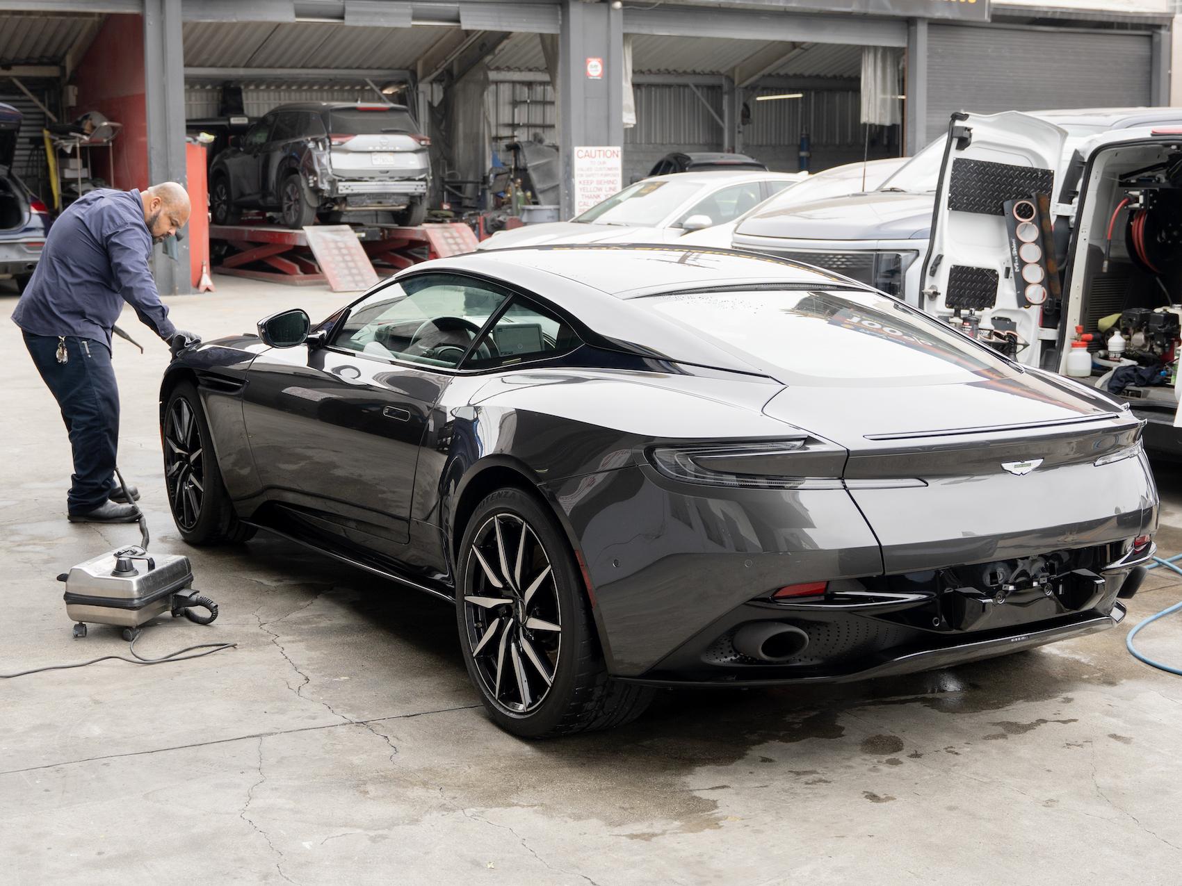 Detailed photo of Aston Martin at auto body shop parking lot after a successful collision repair