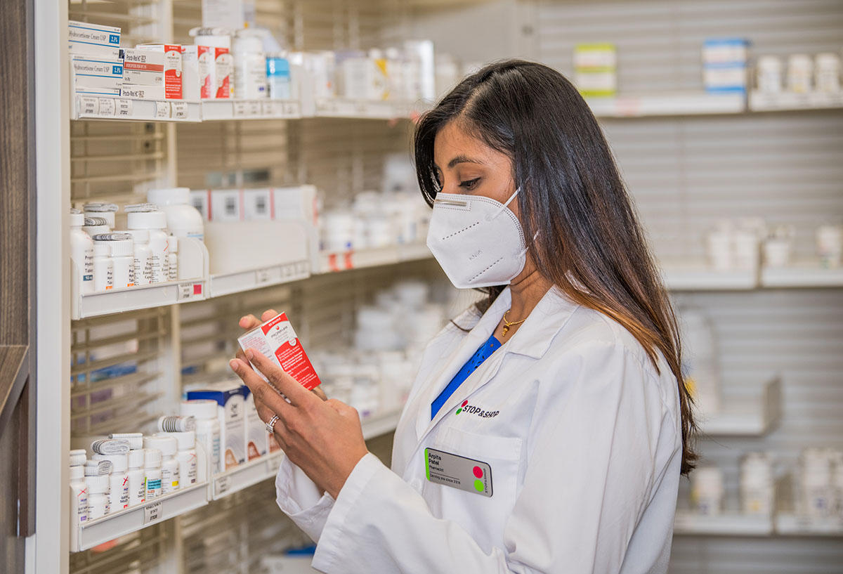 Pharmacist with mask selecting medications