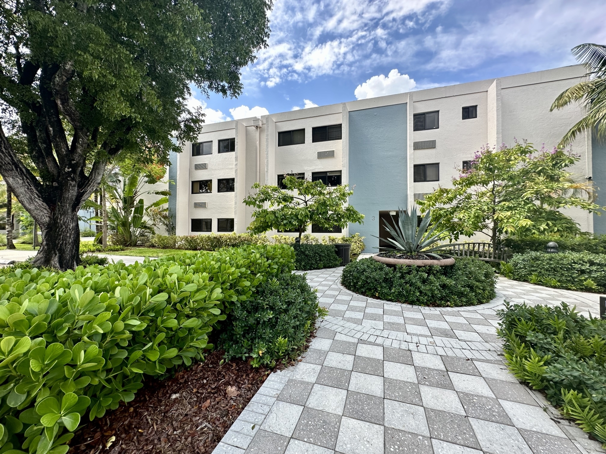 The Solaire At Las Palmas Village exterior with building, a patio and a garden