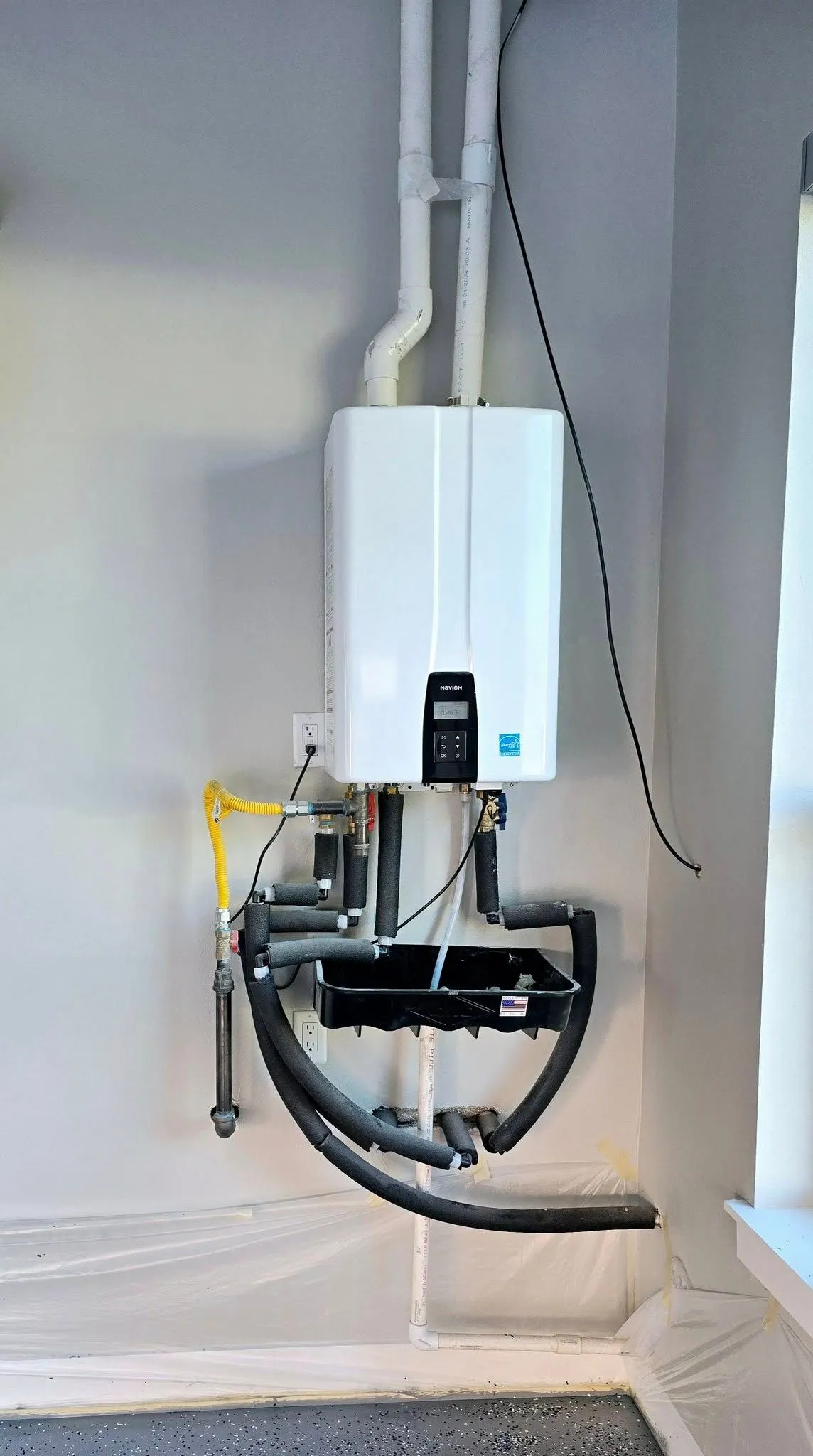 Modern tankless water heater professionally installed with insulated plumbing connections, gas supply, and drainage components, providing efficient hot water, energy savings, and reliable residential plumbing performance for homeowners daily.