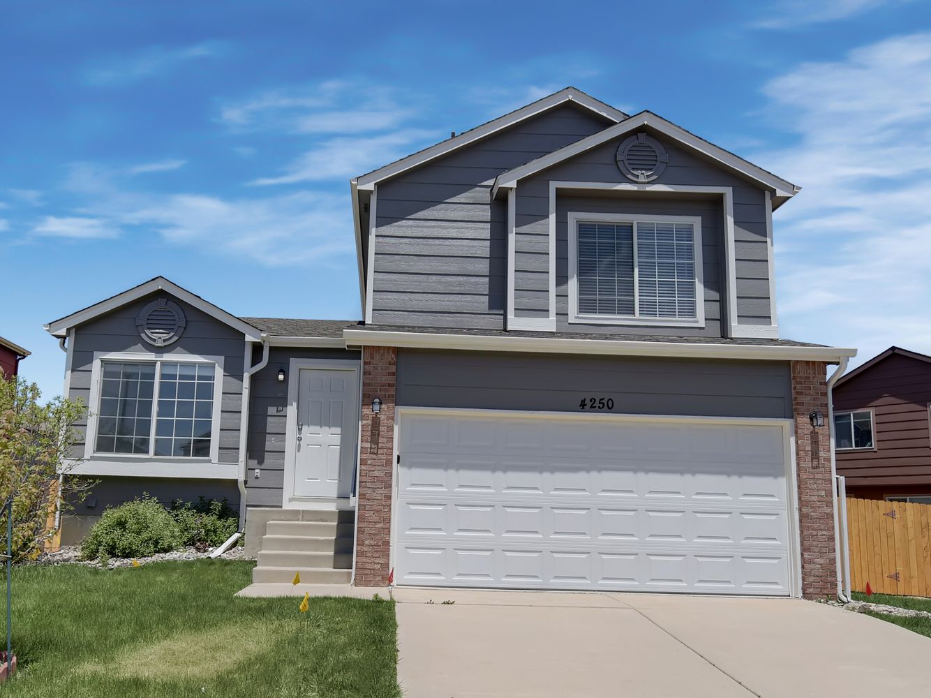 Front of home shot with steps leading up to front door and attached two-car garage at Invitation Homes Denver.