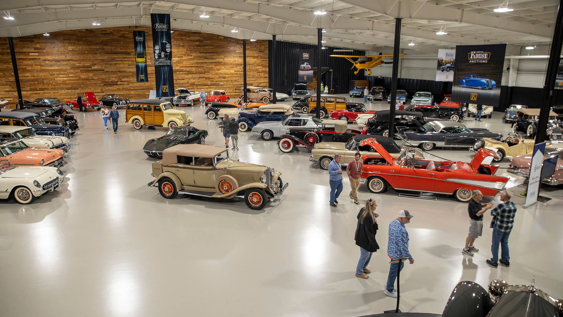 Indoor collector car display at Kruse Auctions in Auburn, Indiana, featuring classic and specialty automobiles.